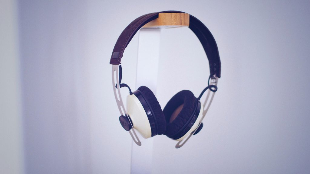 Sleek modern headphones displayed on a minimalist stand in a neutral setting.